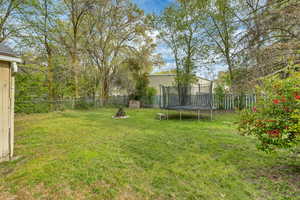 View of yard featuring a fenced backyard and a trampoline