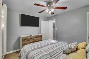 Bedroom featuring carpet floors, baseboards, and ceiling fan