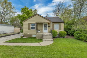 Bungalow featuring roof with shingles, fence, and a front yard