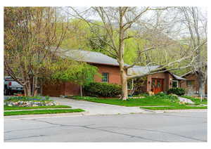 Ranch-style house featuring concrete driveway, a front yard, and brick siding