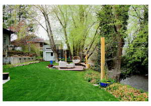 View of yard with an outdoor hangout area, a storage unit, a trampoline, and an outdoor structure