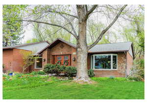 Single story home featuring brick siding, french doors, and a front yard