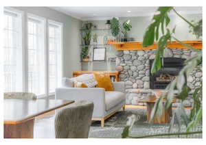 Living area with ornamental molding, a fireplace, and wood finished floors