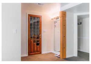 Hall with baseboards, carpet, and visible vents