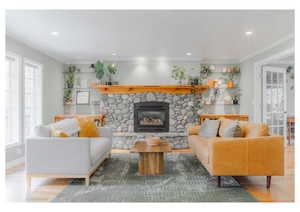 Living area with plenty of natural light, recessed lighting, wood finished floors, and a stone fireplace