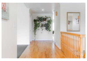 Corridor featuring light wood-style floors, ornamental molding, baseboards, and recessed lighting