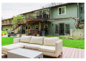 Exterior space featuring a hot tub, outdoor lounge area, a deck, stairway, and a patio area