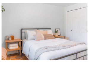 Tiled bedroom featuring a closet