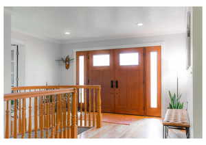 Foyer with recessed lighting, ornamental molding, and light wood finished floors