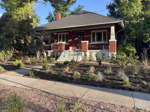 Bungalow-style house with a porch, brick siding, and a chimney