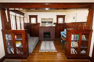 Living area featuring wainscoting, wood finished floors, and a wealth of natural light