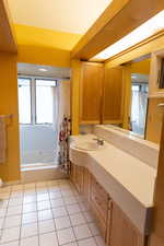 Full bath with toilet, tile patterned floors, shower / tub combo with curtain, and vanity