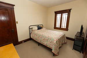 Bedroom featuring baseboards and light carpet