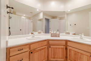 Bathroom featuring double vanity, a sink, and visible vents