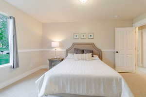 Bedroom featuring baseboards and light colored carpet