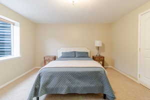 Bedroom with baseboards and light carpet