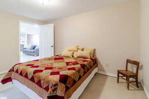 Bedroom featuring concrete floors and baseboards