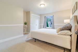 Carpeted bedroom featuring baseboards and a closet