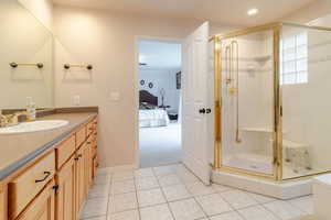 Ensuite bathroom featuring recessed lighting, tile patterned flooring, a shower stall, ensuite bathroom, and vanity