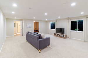 Living area with recessed lighting and light carpet