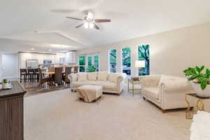 Living area with light wood finished floors, recessed lighting, a ceiling fan, vaulted ceiling, and baseboards