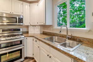 Kitchen featuring white cabinetry, a wealth of natural light, appliances with stainless steel finishes, and a sink