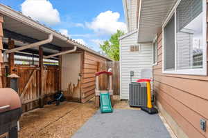 View of patio with fence and central AC unit
