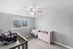 Bedroom with baseboards, ceiling fan, and light carpet