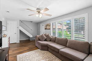 Living area featuring visible vents, stairs, wood finished floors, baseboards, and ceiling fan