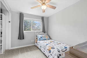 Carpeted bedroom with baseboards and ceiling fan