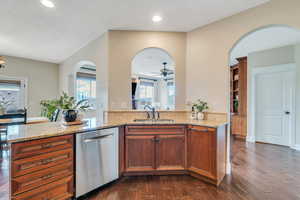 Kitchen features arched openings to family room