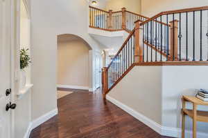 Entryway has arched doorway and beautiful staircase