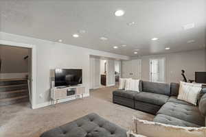 Carpeted living area with stairs, recessed lighting, a textured ceiling, and baseboards