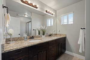 Full primary bath featuring a sink, baseboards, double vanity, and visible vents