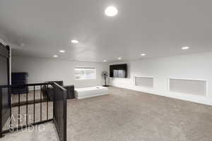 Finished storage area featuring carpet floors, baseboards, recessed lighting, and a barn door access