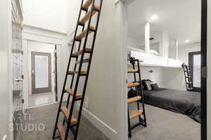 Interior hall with storage closets with access to finished storage area above, carpet, and recessed lighting