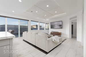 Living room featuring recessed lighting and a raised ceiling