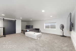 Finished storage room with carpet flooring, recessed lighting, and a barn door