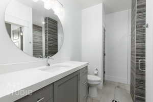 Shared Full bathroom featuring toilet, baseboards, a shower stall, and vanity