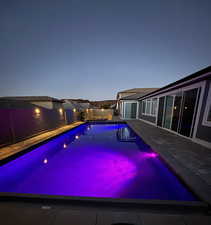 View of swimming pool with a fenced backyard and a patio