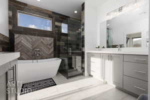 Primary Full bath with vanity, recessed lighting, a freestanding bath, a shower stall, and a wealth of natural light