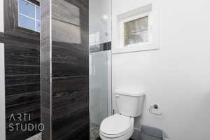Ensuite Full bath with a healthy amount of sunlight, walk in shower, and toilet