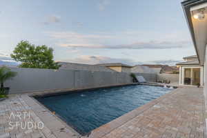 View of pool featuring a fenced backyard, a fenced in pool, and a patio area