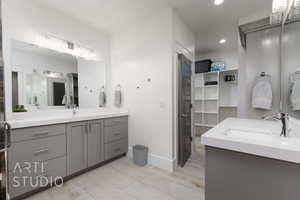 Primary Full bath with vanity, baseboards, recessed lighting, and a walk in closet