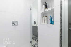 Shared Bathroom featuring vanity and a shower, custom shelving/niches in shower