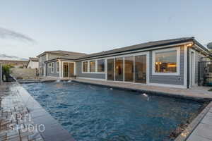 Rear view of house with a fenced in pool, a patio area, and fence