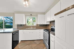 Kitchen with stainless steel electric range oven, a sink, black dishwasher, light tile patterned floors, and tasteful backsplash