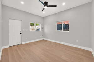 Spare room with a ceiling fan, baseboards, and light wood finished floors