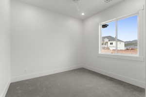 Carpeted spare room featuring baseboards, a ceiling fan, and recessed lighting