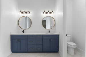 Full bath featuring a sink, toilet, and marble finish floor